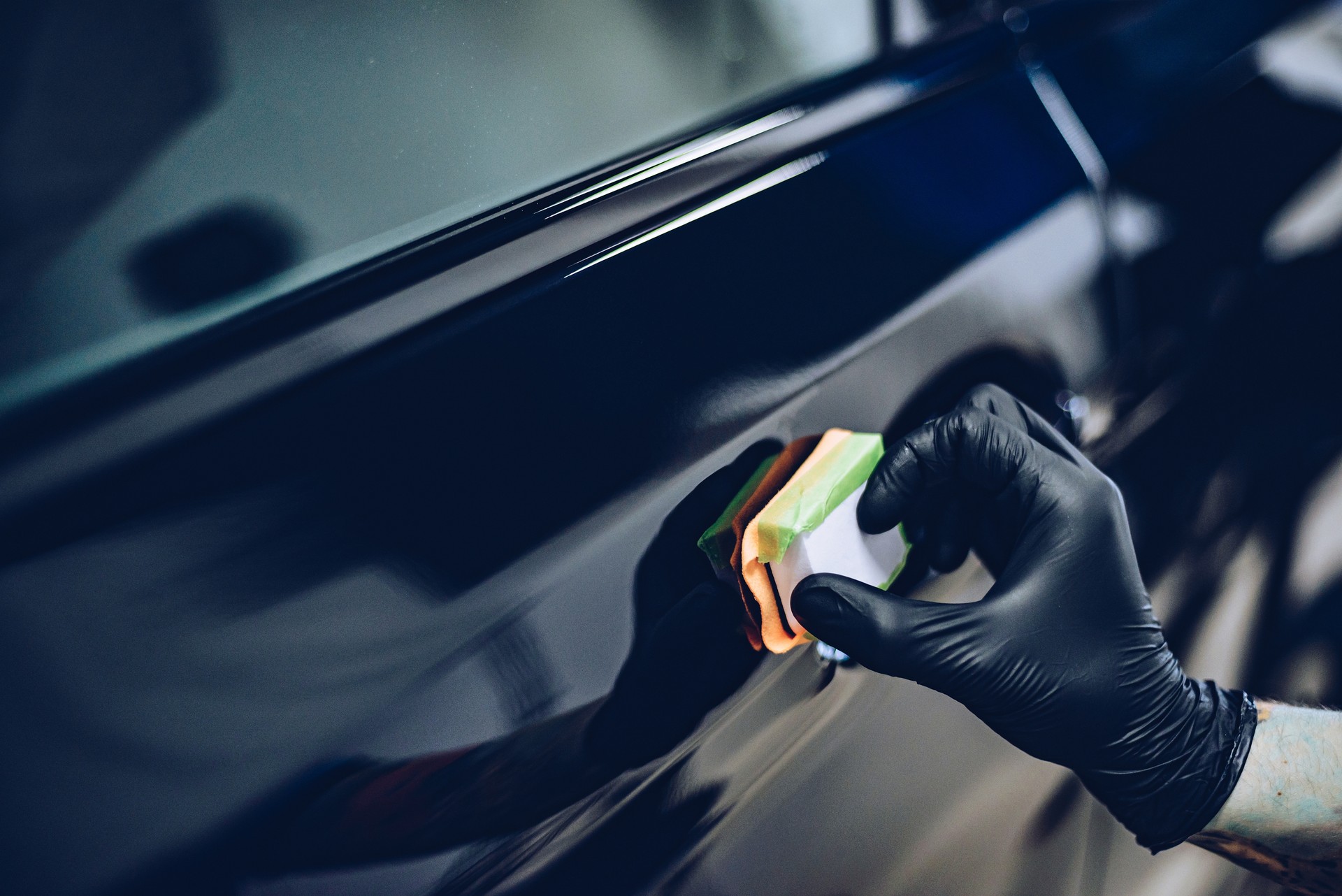 Man worker in car wash polishing car